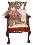 Childs ornately carved wooden chair with cushion and removable seat, and an old rag doll