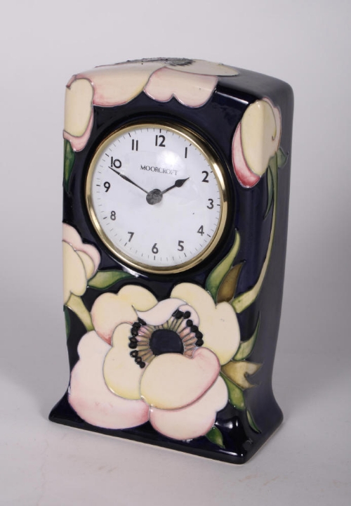 A Moorcroft mantel clock, two Wade decanters and other decorative items