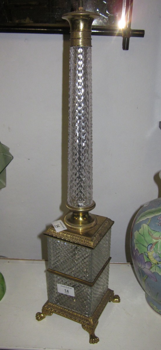 A lozenge cut glass table lamp on square plinth with gilt metal mounts and paw feet, 24"" high, and