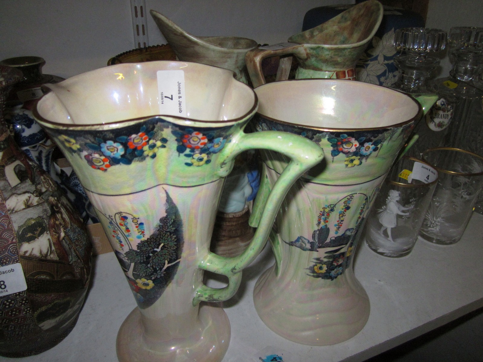 Two Arthur Wood Art Deco lustre decorated jug vases with floral decoration and a pair of relief