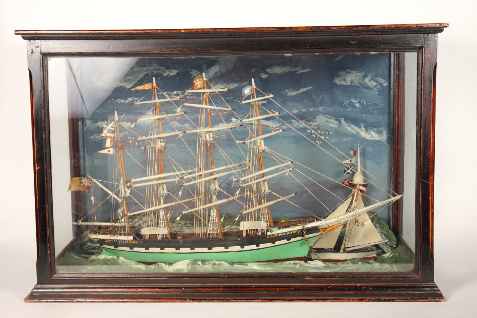 A late 19th Century cased model of a four masthead sailing ship, ""Maggie"", and a small yacht off