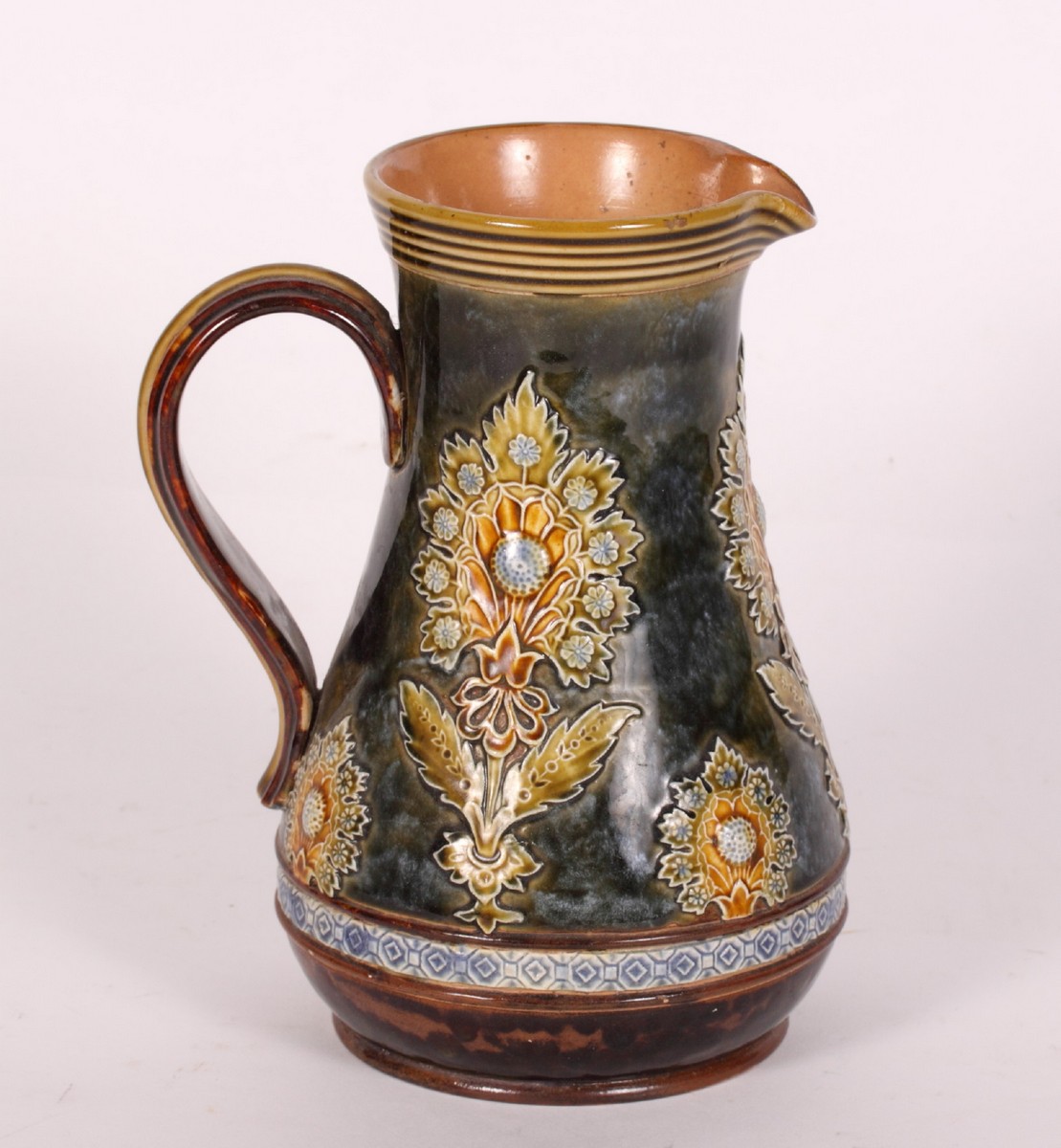 A Doulton Lambeth stoneware jug with floral relief decoration, 8 1/2"" high