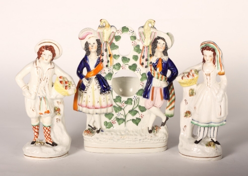 A 19th Century Staffordshire watch group, 12"" high, and a pair of 19th Century Staffordshire