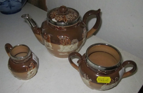 A Doulton two-tone brown glazed stoneware three-piece teaset with sprigged decoration and applied