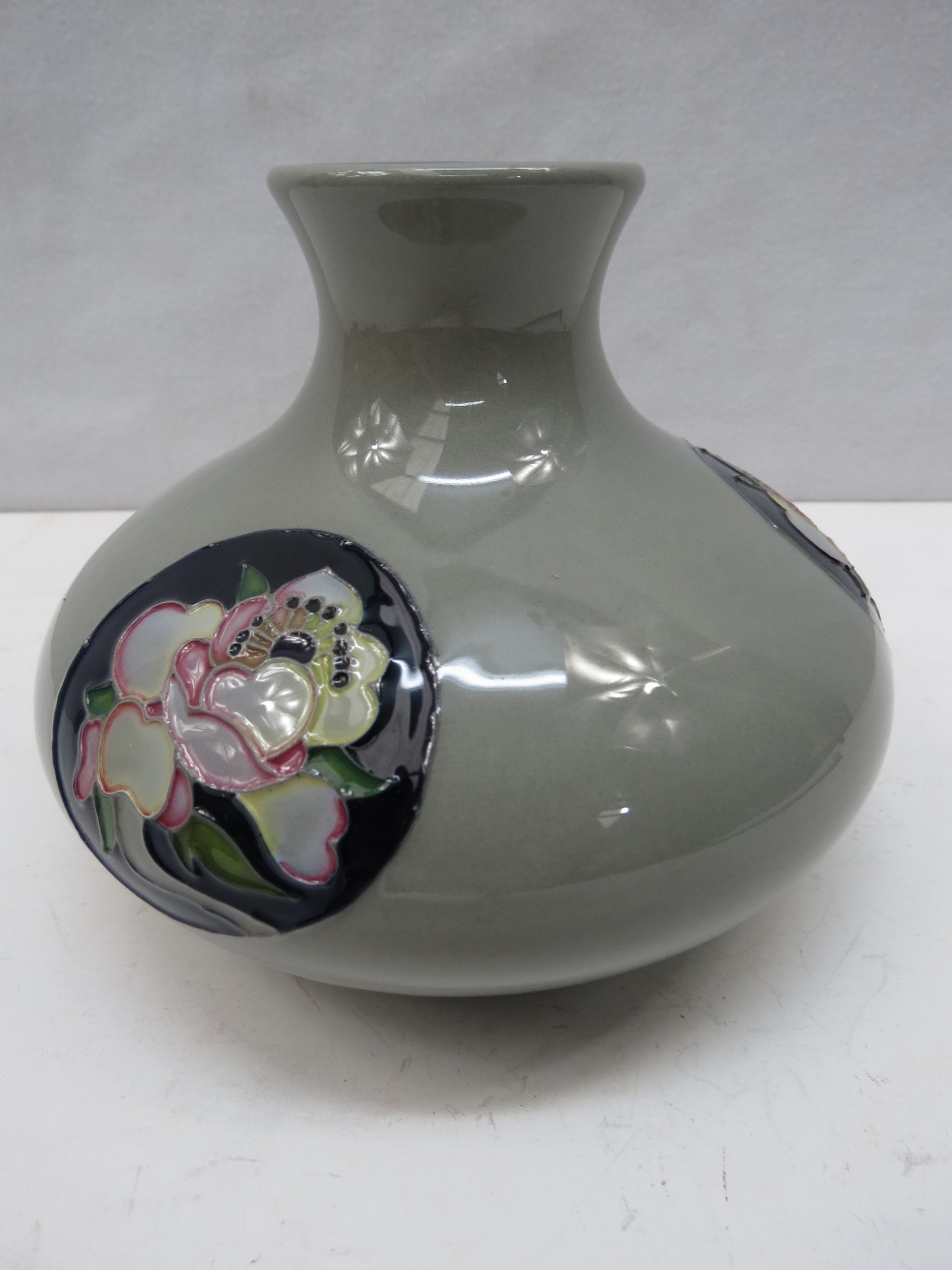 A Moorcroft trial squat shaped vase with rose decorated panels.