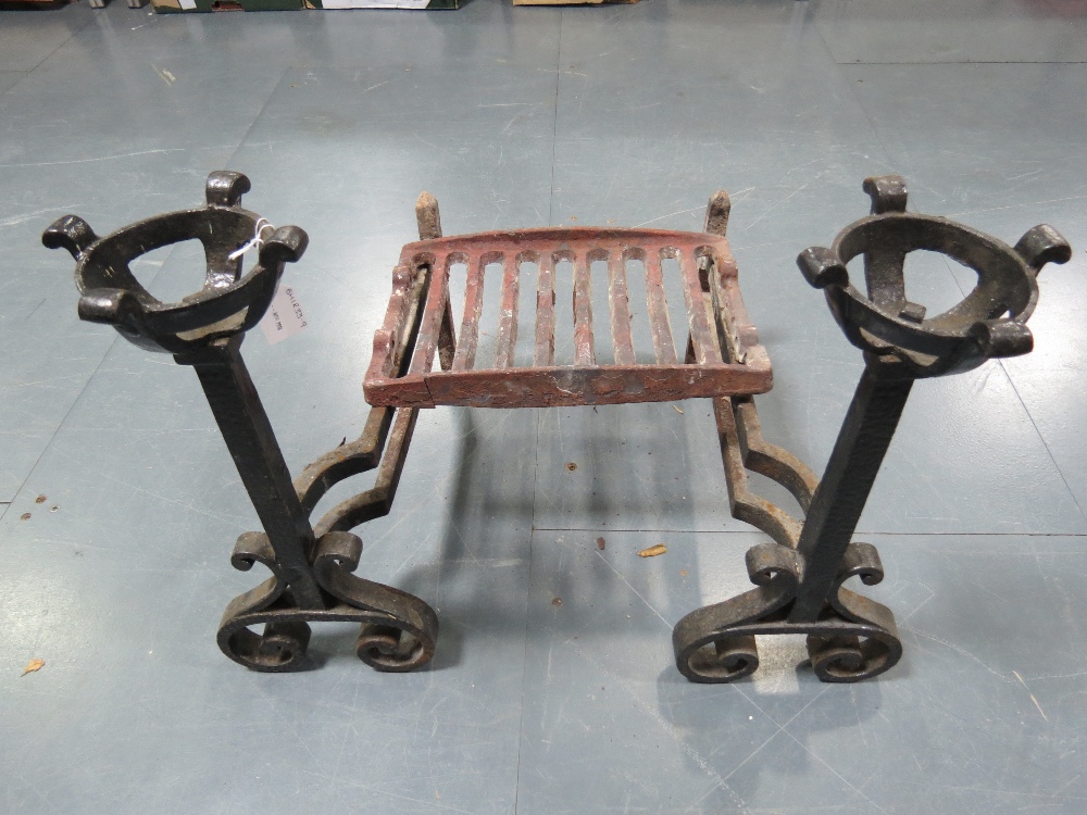 A pair of cast iron andirons of Gothic revival influence complete with grate.