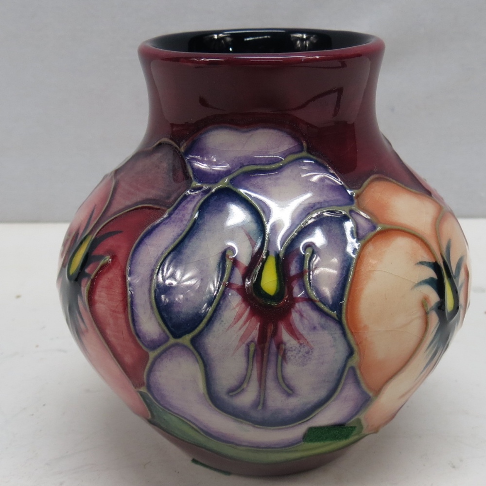 A Moorcroft pansy vase signed by `John Moorcroft` and dated `12.4.97`; 9cm high.