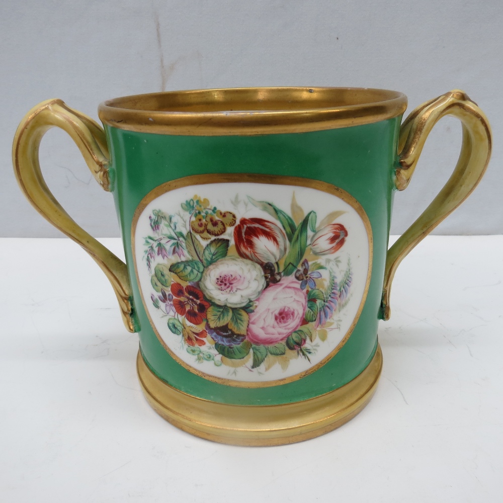 An oversized 19thC green ground  loving cup, hand painted with floral decoration, gilded handles