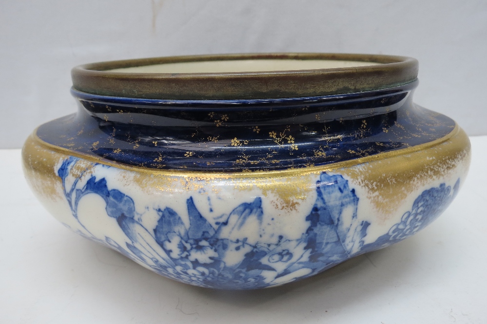 A Doulton Burslem blue and white bowl with metal rim, 26cm wide.