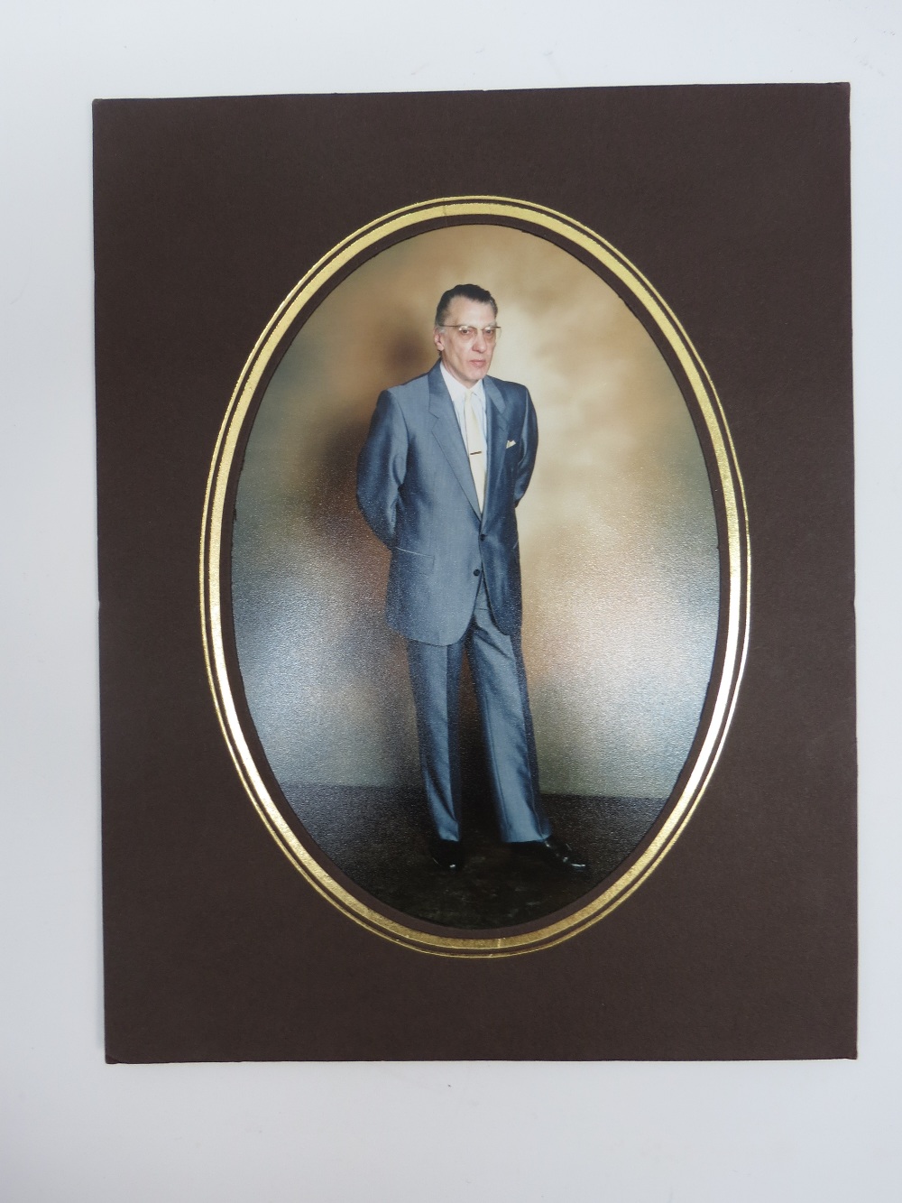 A full length portrait colour photograph of Ronnie Kray, in cardboard mount; sightsize 16.5cm oval.