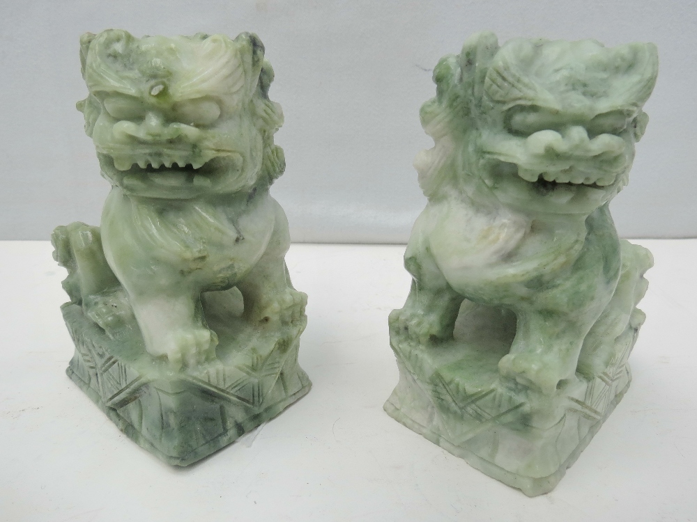 A pair of 19thC hand carved green soapstone temple dogs, each standing 10cm high.