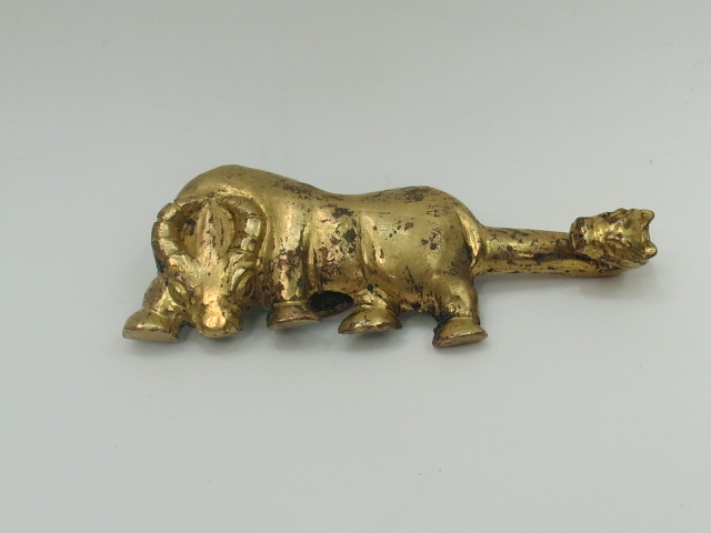 An Oriental gilt bronze buckle in the form of an ox with dragon head tail. Width 8.5cm.