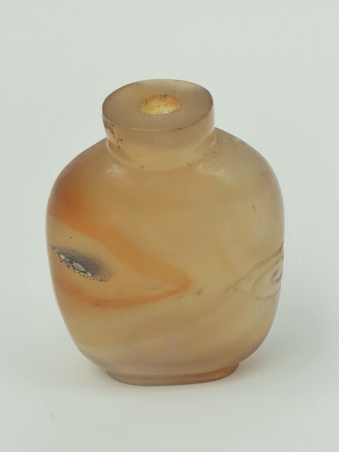 A Chinese `Tiger Eye` snuff bottle with small piece of fruit carved into one side, stopper