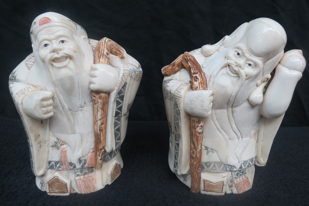 Two bone carvings of Japanese immortal sages with staves and long moustaches, 17cm high.