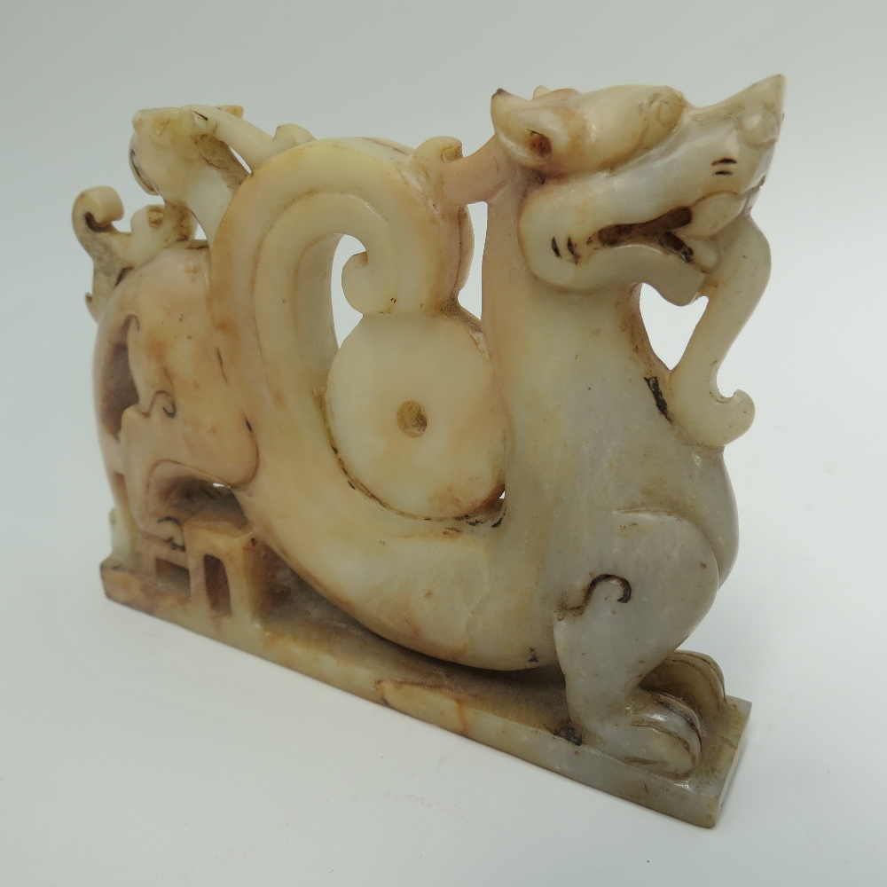 A Chinese mutton fat jade dragon on integral stand, 10cm. 219.5g.