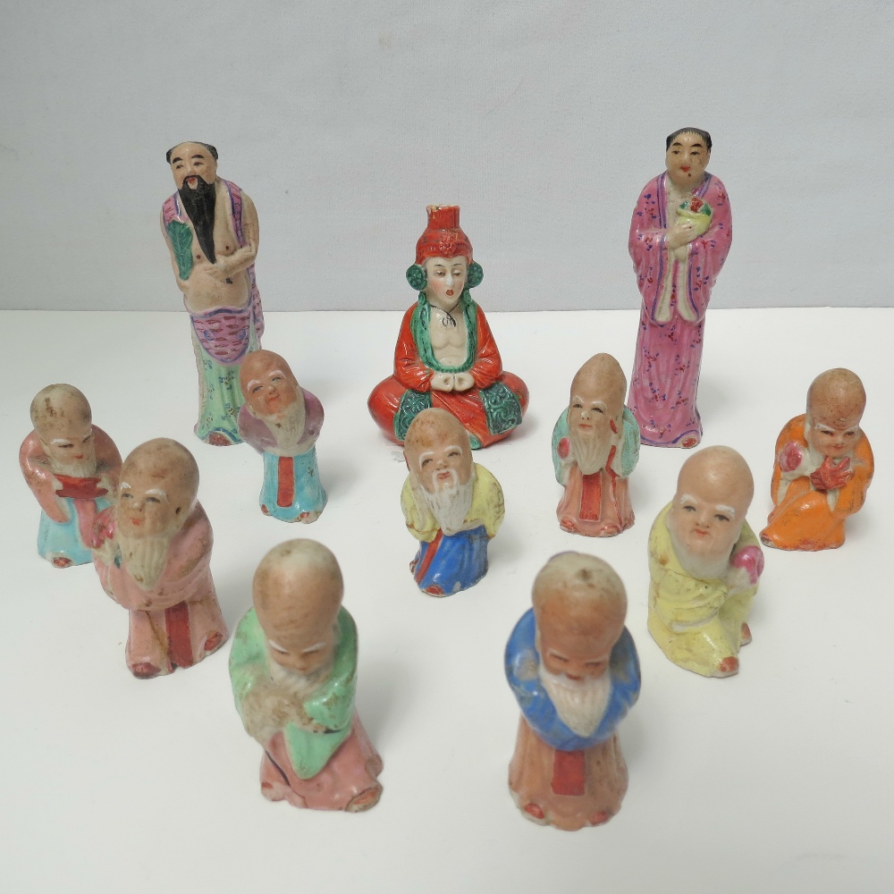 A quantity of nine bulbous headed ceramic Japanese figurines of novelty form, each standing 5cm