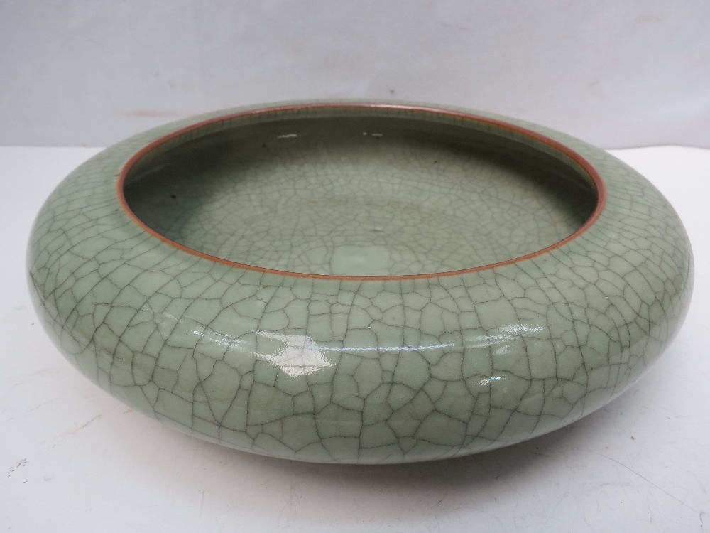 A Chinese crackle glaze celadon bowl, with incurling lip, four character mark to base. Diameter