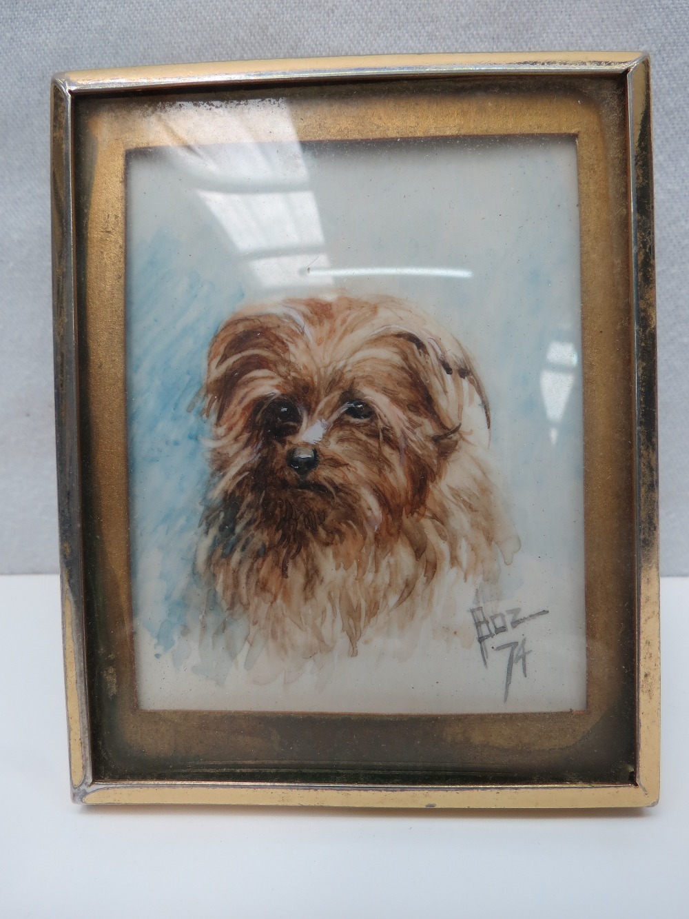 A framed miniature watercolour painting of a terrier.