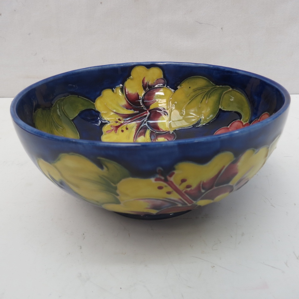 A Walter Moorcroft bowl with Hibiscus design on a blue ground, 16cm.