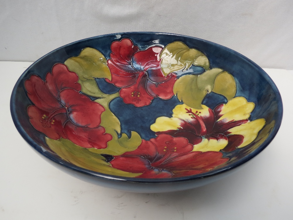 A large Walter Moorcroft bowl with Hibiscus design on a smokey blue ground, 27cm.