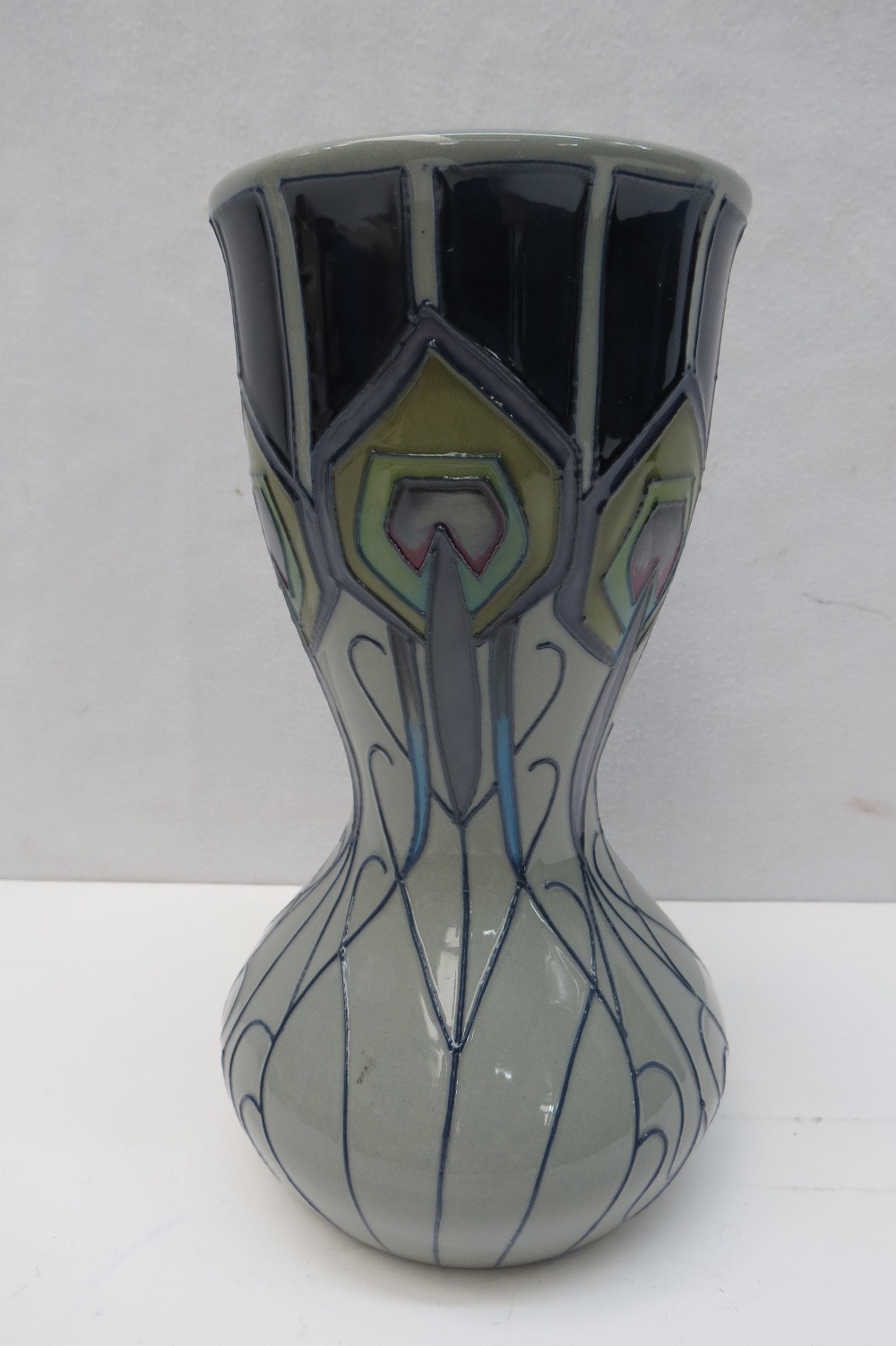 A Moorcroft Peacock Parade made in 2012, the vase has a red dot to base and it measures 18cm high.