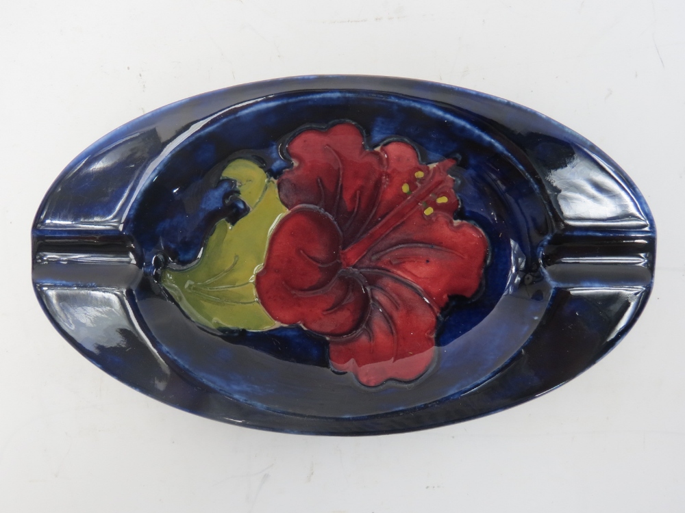 A Walter Moorcroft ashtry with Hibiscus design on a blue ground.