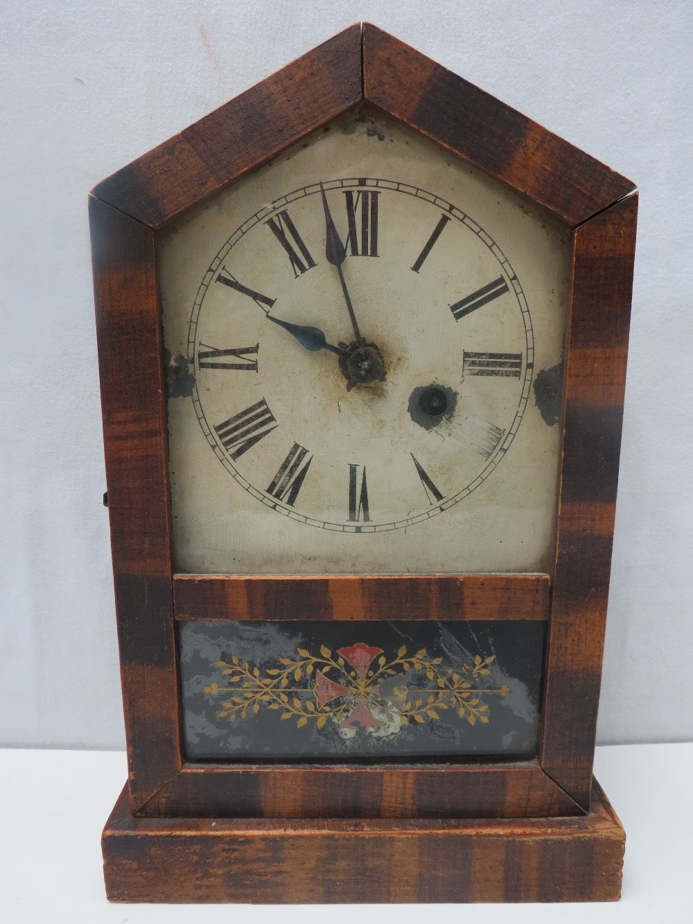 A 19thC mantel clock having painted face and Roman numerals within a deal case, decorated glass