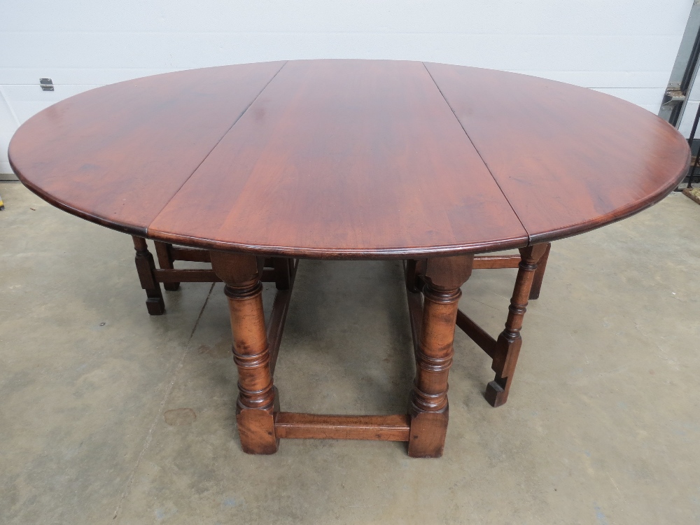 A large and impressive circular table raised over gunbarrel legs with twin swing out support to