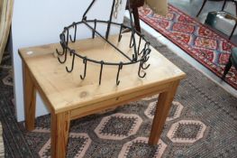 A WROUGHT IRON FIREGUARD IN THE FORM OF A FIVE BAR GATE, A POT HANGER AND A SMALL PINE COFFEE TABLE