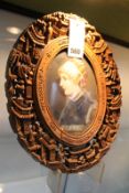 A CONTINENTAL OVAL PORCELAIN PORTRAIT PLAQUE OF A YOUNG LADY MOUNTED IN A CHINESE EXPORT CARVED