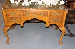 A WALNUT WRITING TABLE ON CABRIOLE LEGS