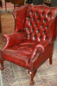 A GEORGIAN STYLE LEATHER UPHOLSTERED WING BACK ARMCHAIR