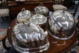 FOUR ANTIQUE PLATED MEAT COVERS AND A WARMING DISH