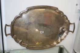 A LARGE HALLMARKED SILVER OVAL SHAPED EDGE TWO HANDLED TRAY, WITH ENGRAVED ARMS TO CENTRE.