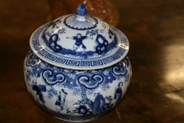 A CHINESE BLUE AND WHITE COVERED BOWL OF SQUAT FORM WITH FIGURAL DECORATION. CHARACTER MARK