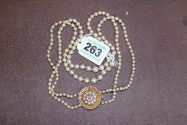 A CULTURED PEARL DOUBLE STRAND NECKLACE SET WITH 9CT GOLD AND AMETHYST CLASP.