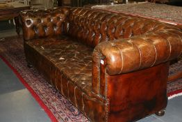A PAIR OF LEATHER UPHOLSTERED BUTTON BACK CHESTERFIELD SOFAS