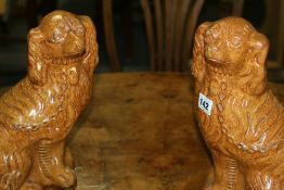 A PAIR OF UNUSUAL SALT GLAZED POTTERY SPANIELS