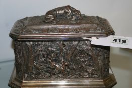 A VICTORIAN SILVERED JEWELLERY CASKET DECORATED WITH HUNTING SCENES. RECUMBENT HOUND FINIAL