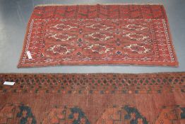 AN ANTIQUE TURKOMAN BAG FACE AND AN AFGHAN RUG.