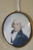 A GEORGIAN OVAL MINIATURE WATERCOLOUR PORTRAIT OF A GENTLEMAN, THE ENCLOSED YELLOW METAL FRAME