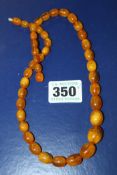 A STRING OF AMBER BEADS.