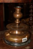 AN ANTIQUE PATINATED BRASS BELL FORM CANDLESTICK