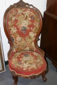 A VICTORIAN NURSING CHAIR WITH CARVED SHOW FRAME AND NEEDLEWORK UPHOLSTERY TOGETHER WITH A SIMILAR