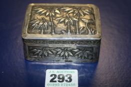 AN ORIENTAL SILVER BOX WITH REPOUSSE DECORATION