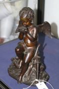 AN ANTIQUE BRONZE FIGURE OF CUPID SEATED ON A ROCK, PROBABLY FRENCH