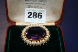 AN ANTIQUE YELLOW METAL AMETHYST AND SEED PEARL SET BROOCH