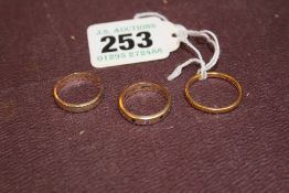 A 22CT GOLD WEDDING RING AND TWO OTHER RINGS. (3)