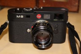 A LEICA M8 CAMERA WITH SUMMICRON 1:2/50 LENS WITH LEATHER LEICA CASE TOGETHER WITH INSTRUCTION