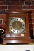 A WALNUT CASED BRACKET CLOCK WITH BRASS AND SILVERED DIAL.